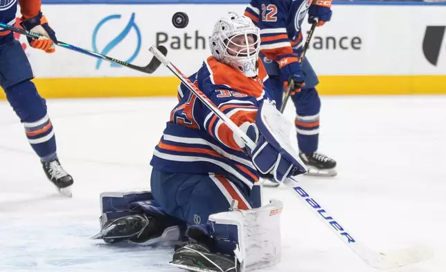 Edmonton Oilers' goalie Connor Ingram, center, makes a save against the Vegas Golden Knights during first-period NHL hockey game action in Edmonton, Alberta, Sunday, Dec. 21, 2025. (Jason Franson/The Canadian Press via AP)