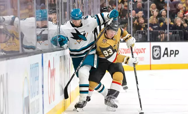 San Jose Sharks defenseman John Klingberg (3) and Vegas Golden Knights right wing Mitch Marner (93) fight for the puck during the second period of an NHL hockey game Tuesday, Dec. 23, 2025, in Las Vegas. (AP Photo/Steve Marcus)