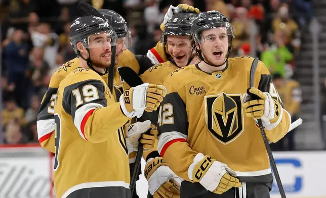 Vegas Golden Knights right wing Reilly Smith (19) celebrates with, from left, defenseman Brayden McNabb (3), defenseman Kaedan Korczak (6), and right wing Braeden Bowman (42) after his goal against the San Jose Sharks during the second period of an NHL hockey game Tuesday, Dec. 23, 2025, in Las Vegas. (AP Photo/Steve Marcus)