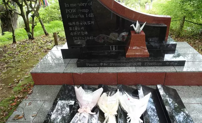Flowers are placed by relatives of former Dutch POWs at a monument dedicated to those held captive at the Fukuoka No. 14 Camp during a memorial service in Nagasaki, western Japan, Friday, Sept. 12, 2025. (AP Photo/Mari Yamaguchi)