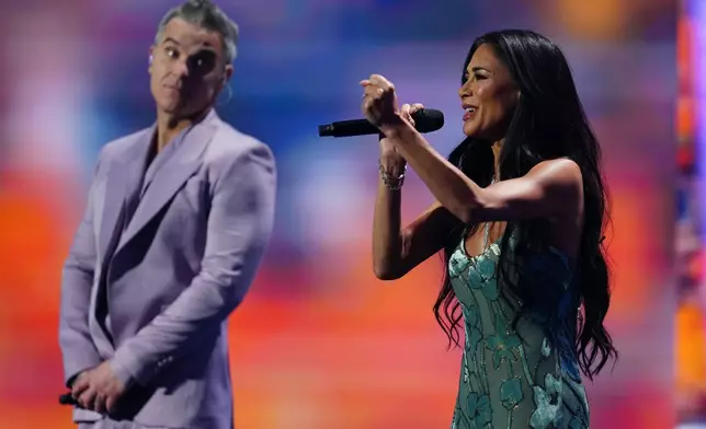 Singer Robbie Williams and singer and actor Nicole Scherzinger perform during the draw for the 2026 soccer World Cup at the Kennedy Center in Washington, Friday, Dec. 5, 2025. (AP Photo/Jacquelyn Martin)