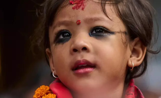 FILE - Nepal's newly appointed living goddess, Kumari Aryatara Shakya, is carried toward Kumari Ghar, the temple palace where she will be residing in Kathmandu, Nepal, Sept. 30, 2025. (AP Photo/Niranjan Shrestha, File)