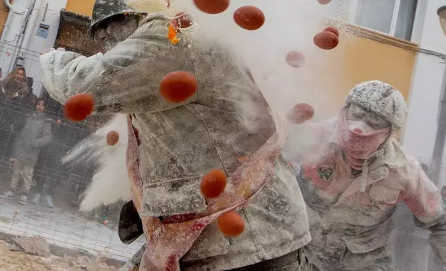 FILE - Revellers take part in the Els Enfarinats festival, a battle using flour, eggs and firecrackers, in the town of Ibi near Alicante, Spain, Sunday Dec. 28, 2025. (AP Photo/Alberto Saiz, FIle)