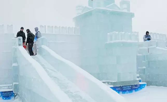 FILE - A girl slides down an ice slide built in the shape of the Kremlin for the Icy Moscow festival at the Victory park in Moscow, Russia, Tuesday, Dec. 30, 2025, as the monument to the Heroes of the First World War is seen in the background. (AP Photo/Pavel Bednyakov, File)
