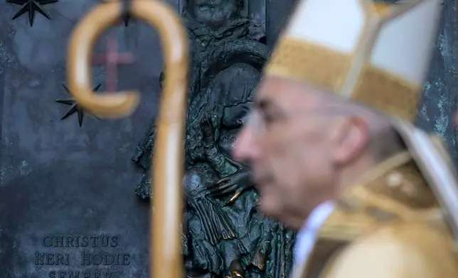 FILE - Italian Cardinal Baldo Reina, Vicar General for the Diocese of Rome, stands in front of the closed Holy Door of the Archbasilica of Saint John Lateran during a ceremony as part of the rites marking the conclusion of the 2025 Jubilee year, in Rome, Saturday, Dec. 27, 2025. (Riccardo Antimiani/Pool Photo via AP, File)