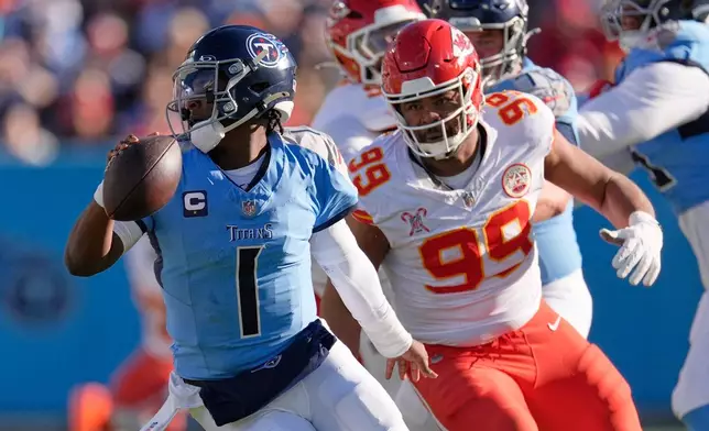 Tennessee Titans quarterback Cam Ward (1) is chased by Kansas City Chiefs defensive tackle Jerry Tillery (99) during the first half of an NFL football game, Sunday, Dec. 21, 2025, in Nashville, Tenn. (AP Photo/George Walker IV)