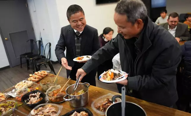 Former Chinese official Li Chuanliang, left, shares a meal with other members of the Mayflower Church, a Christian community which fled religious persecution in China, and American pastors who have welcomed the refugees, in Midland, Texas, Jan. 19, 2025. (AP Photo/Rebecca Blackwell)