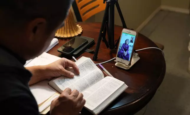 Former Chinese official Li Chuanliang reads the Bible to his elderly mother, Shen Shuzi, who is back in China, over a video call in Midland, Texas, Jan. 18, 2025. (AP Photo/Rebecca Blackwell)