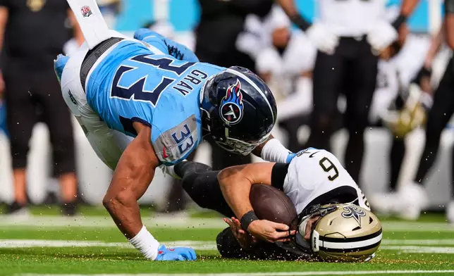 New Orleans Saints quarterback Tyler Shough (6) is hist by Tennessee Titans linebacker Cedric Gray (33) as he slides on a carry in the first half of an NFL football game, Sunday, Dec. 28, 2025, in Nashville, Tenn. (AP Photo/George Walker IV)