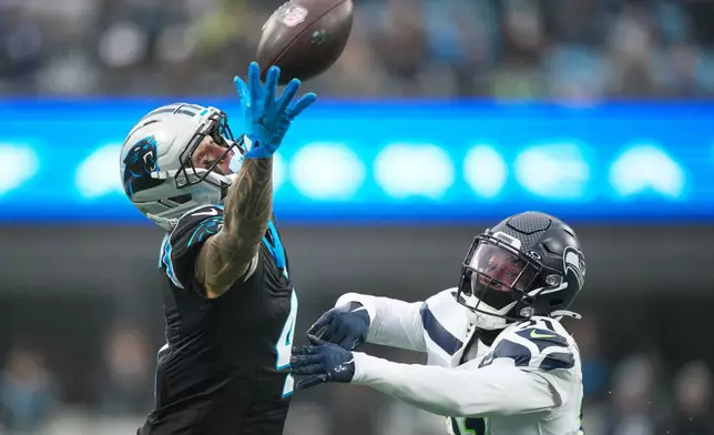 Seattle Seahawks cornerback Devon Witherspoon breaks up a pass intended for Carolina Panthers wide receiver Tetairoa McMillan during the first half of an NFL football game, Sunday, Dec. 28, 2025, in Charlotte, N.C. (AP Photo/Jacob Kupferman)