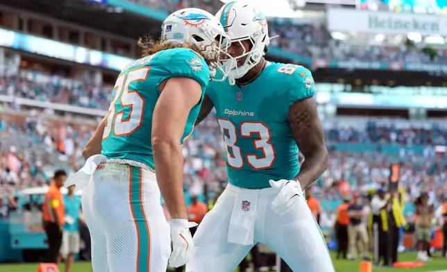 Miami Dolphins tight end Greg Dulcich (85) celebrates with tight end Darren Waller (83) after scoring a touchdown against the Tampa Bay Buccaneers during the first half of an NFL football game Sunday, Dec. 28, 2025, in Miami Gardens, Fla. (AP Photo/Rebecca Blackwell)