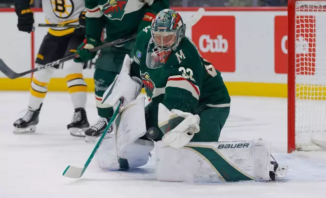 Minnesota Wild goaltender Filip Gustavsson (32) makes a glove-save during the first period of an NHL hockey game against the Boston Bruins, Sunday, Dec. 14, 2025, in St. Paul, Minn. (AP Photo/Bailey Hillesheim)