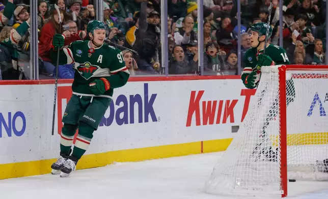 Minnesota Wild left wing Kirill Kaprizov (97) celebrates with center Joel Eriksson Ek (14) after scoring during the second period of an NHL hockey game against the Boston Bruins, Sunday, Dec. 14, 2025, in St. Paul, Minn. (AP Photo/Bailey Hillesheim)
