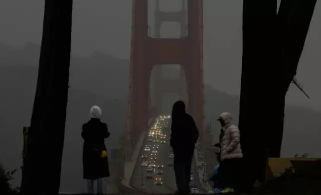 People look toward traffic on the Golden Gate Bridge from the Golden Gate Overlook in San Francisco, Tuesday, Dec. 23, 2025. (AP Photo/Jeff Chiu)