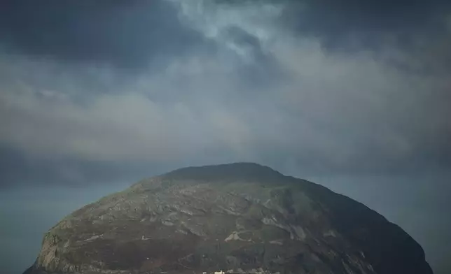 The island of Ailsa Craig, where the two types of granite, Common Green and Blue Hone, that are used to make curling stones is quarried from, is seen from the beach at Girvan, Scotland, Thursday, Nov. 13, 2025. (AP Photo/Alastair Grant)