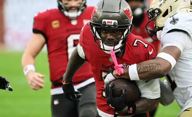 Tampa Bay Buccaneers running back Bucky Irving (7) carries against the New Orleans Saints in the second half of an NFL football game, Sunday, Dec. 7, 2025, in Tampa, Fla. (AP Photo/Jason Behnken)