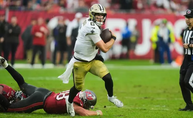 New Orleans Saints quarterback Tyler Shough (6) carries for a touchdown past Tampa Bay Buccaneers safety Rashad Wisdom (38) in the second half of an NFL football game, Sunday, Dec. 7, 2025, in Tampa, Fla. (AP Photo/Chris O'Meara)