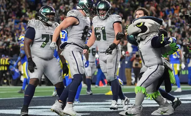 Seattle Seahawks tight end Eric Saubert, second from left, celebrates after making a two-point conversion during overtime in an NFL football game against the Los Angeles Rams, Thursday, Dec. 18, 2025, in Seattle. (AP Photo/Lindsey Wasson)