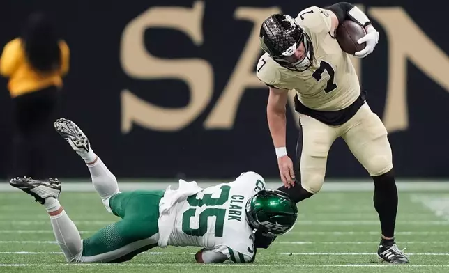 New Orleans Saints tight end Taysom Hill (7) holds on to the ball after a pass completion as New York Jets safety Dean Clark (35) defends during the first half of an NFL football game Sunday, Dec. 21, 2025, in New Orleans. (AP Photo/Gerald Herbert)