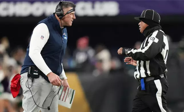 New England Patriots head coach Mike Vrabel, left, reacts toward down judge Patrick Turner (13) during the first half of an NFL football game against the Baltimore Ravens, Sunday, Dec. 21, 2025, in Baltimore. (AP Photo/Stephanie Scarbrough)