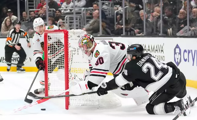 Los Angeles Kings center Phillip Danault, right, tries to get a shot in as Chicago Blackhawks defenseman Connor Murphy, left, and goaltender Spencer Knight defend during the second period of an NHL hockey game Thursday, Dec. 4, 2025, in Los Angeles. (AP Photo/Mark J. Terrill)