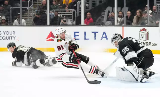 Chicago Blackhawks center Frank Nazar, center, tries to score on Los Angeles Kings goaltender Darcy Kuemper, right, as defenseman Mikey Anderson falls during the third period of an NHL hockey game Thursday, Dec. 4, 2025, in Los Angeles. (AP Photo/Mark J. Terrill)