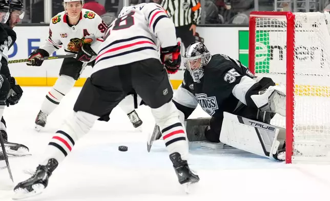 Chicago Blackhawks left wing Andre Burakovsky, center, tries to get a shot past Los Angeles Kings goaltender Darcy Kuemper during the first period of an NHL hockey game Thursday, Dec. 4, 2025, in Los Angeles. (AP Photo/Mark J. Terrill)