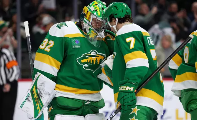 Minnesota Wild goaltender Filip Gustavsson, left, and defenseman Brock Faber (7) celebrate their win against the Dallas Stars after an NHL hockey game Thursday, Dec. 11, 2025, in St. Paul, Minn. (AP Photo/Matt Krohn)