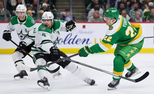 Minnesota Wild right wing Danila Yurov (22) shoots the puck as Dallas Stars defenseman Miro Heiskanen (4) defends during the second period of an NHL hockey game Thursday, Dec. 11, 2025, in St. Paul, Minn. (AP Photo/Matt Krohn)