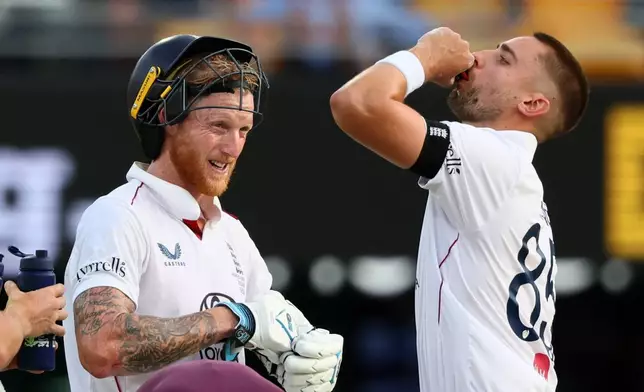 England's captain Ben Stokes, left, and England's Will Jacks takes refreshment during the second Ashes cricket test match between Australia and England in Brisbane, Sunday, Dec. 7, 2025.. (AP Photo/Tertius Pickard)