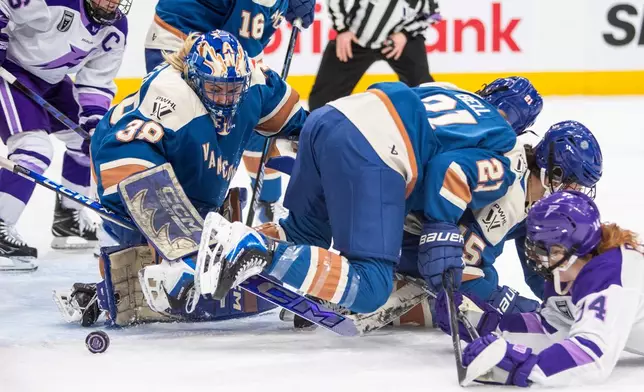 Vancouver Goldeneyes goalie Emerance Maschmeyer (38) keeps out Minnesota Frost Dominique Petrie as Kendall Coyne-Schofield (26) looks on and Ashton Bell (21) and Gabby Rosenthal look for the puck during the first period of a PWHL hockey game in Edmonton, Alberta, Saturday Dec. 27, 2025. (Amber Bracken/The Canadian Press via AP)