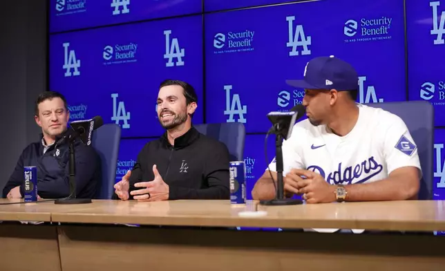 Los Angeles Dodgers General Manager Brandon Gomes, middle, speaks during an introduction of Edwin Díaz, right, as a new member of the baseball team Friday, Dec. 12, 2025, in Los Angeles. (AP Photo/Ethan Swope)