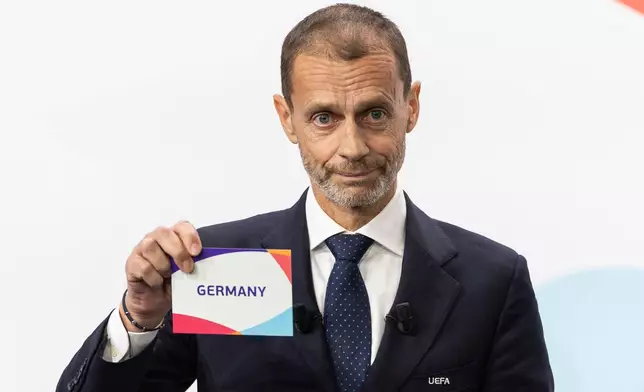 UEFA president Aleksander Ceferin shows the name of Germany, during the the announcement ceremony for the host country of the UEFA Women's EURO 2029, in Nyon, Switzerland, Wednesday, Dec. 3, 2025. (Cyril Zingaro/Keystone via AP)