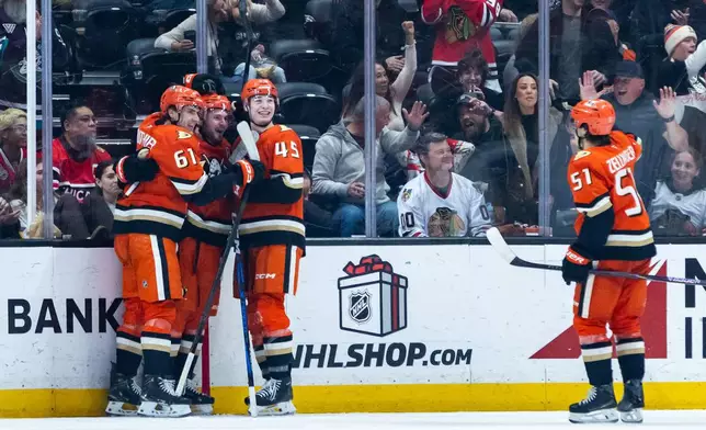 Anaheim Ducks left wing Cutter Gauthier (61), center Mason McTavish (23), right wing Beckett Sennecke (45), and defenseman Olen Zellweger (51) celebrate after scoring against the Chicago Blackhawks during the second period of an NHL hockey game Sunday, Dec. 7, 2025, in Anaheim, Calif. (AP Photo/Ethan Swope)