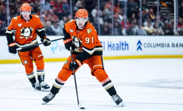 Anaheim Ducks center Leo Carlsson (91) controls the puck against the Chicago Blackhawks during the first period of an NHL hockey game Sunday, Dec. 7, 2025, in Anaheim, Calif. (AP Photo/Ethan Swope)