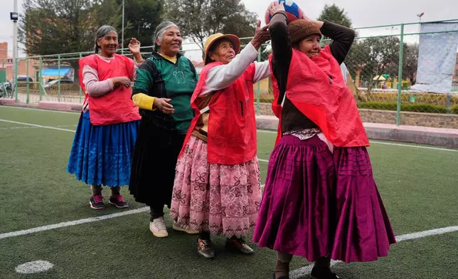 FILE - An Aymara grandmother passes the ball during a warm up before the start of a handball match in El Alto, Bolivia, Dec. 9, 2025. (AP Photo/Juan Karita, File)