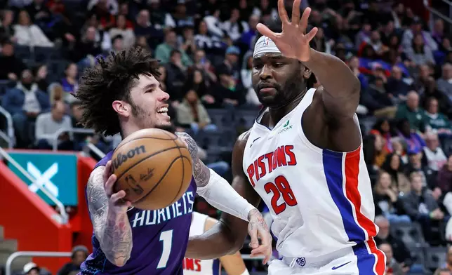 Charlotte Hornets guard LaMelo Ball (1) looks to pass the ball against Detroit Pistons forward Isaiah Stewart (28) during the first half of an NBA basketball game, Saturday, Dec. 20, 2025, in Detroit. (AP Photo/Duane Burleson)