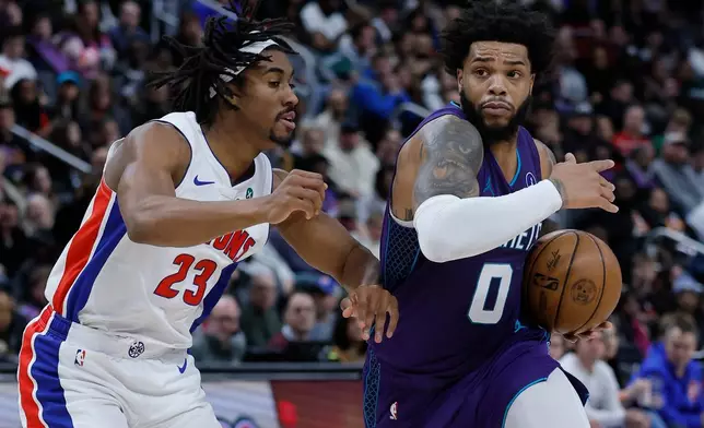 Charlotte Hornets forward Miles Bridges (0) drives against Detroit Pistons guard Jaden Ivey (23) during the first half of an NBA basketball game, Saturday, Dec. 20, 2025, in Detroit. (AP Photo/Duane Burleson)