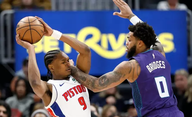 Detroit Pistons guard Ausar Thompson (9) tries going to the basket against Charlotte Hornets forward Miles Bridges (0) during the first half of an NBA basketball game, Saturday, Dec. 20, 2025, in Detroit. (AP Photo/Duane Burleson)