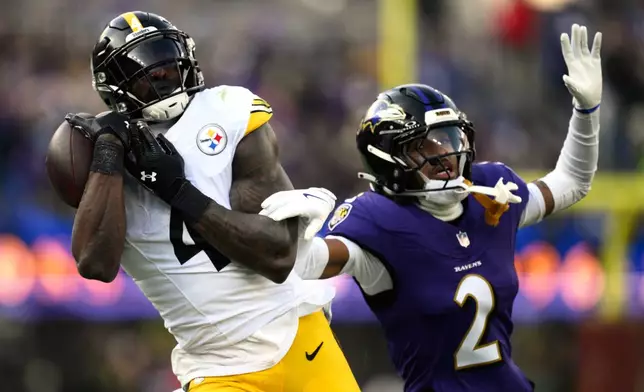 Pittsburgh Steelers wide receiver DK Metcalf (4) catches a pass against Baltimore Ravens cornerback Nate Wiggins (2) during the first half of an NFL football game, Sunday, Dec. 7, 2025, in Baltimore. (AP Photo/Nick Wass)
