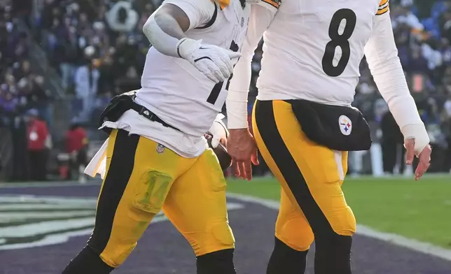 Pittsburgh Steelers running back Kenneth Gainwell (14) celebrates with quarterback Aaron Rodgers (8) after a touchdown during the first half of an NFL football game against the Baltimore Ravens, Sunday, Dec. 7, 2025, in Baltimore. (AP Photo/Stephanie Scarbrough)