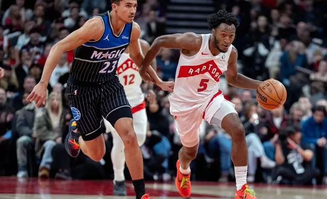 Toronto Raptors guard Immanuel Quickley (5) works upcourt against Orlando Magic forward Tristan da Silva (23) during first-half NBA basketball game action in Toronto, Monday Dec. 29, 2025. (Frank Gunn/The Canadian Press via AP)