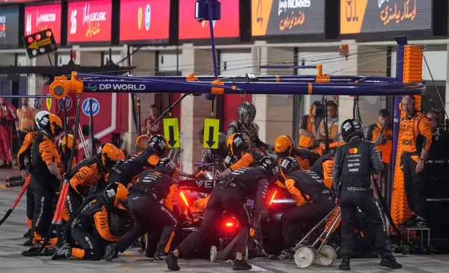 Mechanics change tyures on the car of McLaren driver Oscar Piastri of Australia during the Qatar Formula One Grand Prix in Lusail, Qatar, Sunday, Nov. 30, 2025.(AP Photo/Altaf Qadri, Pool)