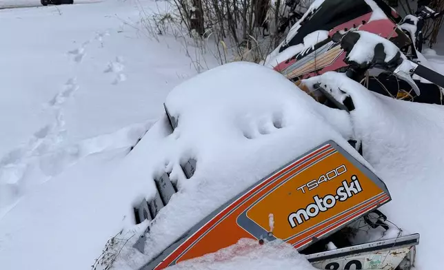 Fresh snow covers old snowmobiles on display in Lowville, N.Y,, on Saturday, Dec. 27, 2025. (AP Photo/Cara Anna)