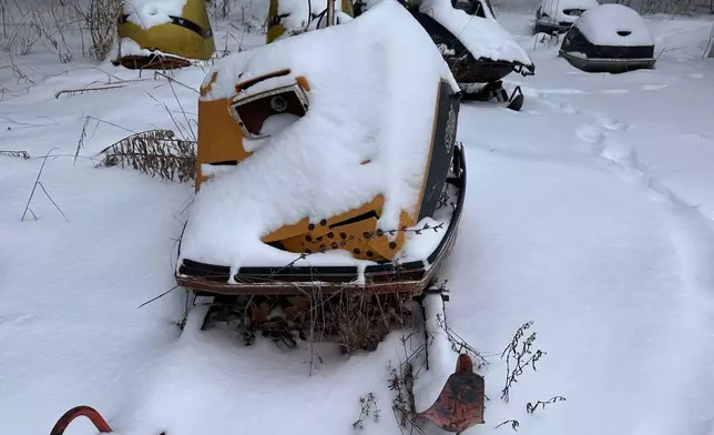 Fresh snow covers old snowmobiles on display in Lowville, N.Y.,on Saturday, Dec. 27, 2025. (AP Photo/Cara Anna)