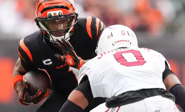 Cincinnati Bengals wide receiver Ja'Marr Chase (1) looks to get past Arizona Cardinals cornerback Will Johnson (0) during the first half of an NFL football game Sunday, Dec. 28, 2025, in Cincinnati. (AP Photo/Jeff Dean)