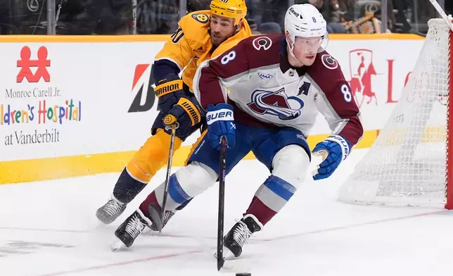 Colorado Avalanche defenseman Cale Makar (8) skates the puck past Nashville Predators center Ryan O'Reilly (90) during the second period of an NHL hockey game Tuesday, Dec. 9, 2025, in Nashville, Tenn. (AP Photo/George Walker IV)