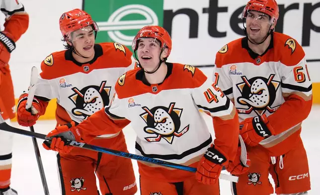 Anaheim Ducks' Beckett Sennecke (45) celebrates with Cutter Gauthier (61) and Olen Zellweger (51) after scoring during the third period of an NHL hockey game against the Pittsburgh Penguins in Pittsburgh, Tuesday, Dec. 9, 2025. (AP Photo/Gene J. Puskar)