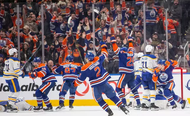The Edmonton Oilers and fans celebrate while Buffalo Sabres look on after Connor McDavid (97), not pictured, scored a game-tying goal with one second on the clock during the third period of an NHL hockey game in Edmonton, Tuesday, Dec. 9, 2025. (Amber Bracken/The Canadian Press via AP)