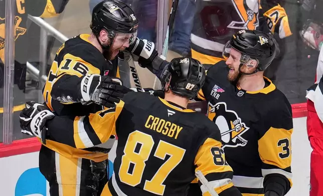 Pittsburgh Penguins' Justin Brazeau (16) celebrates his goal with Sidney Crosby (87) and Anthony Mantha during the first period of an NHL hockey game against the Carolina Hurricanes in Pittsburgh, Tuesday, Dec. 30, 2025. (AP Photo/Gene J. Puskar)
